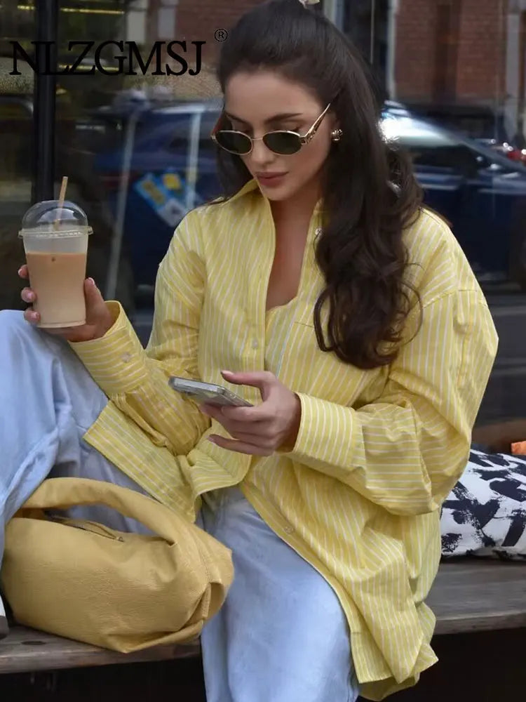 Stylish woman enjoying coffee in an Elegant Stripe Long Sleeve Casual Shirt for Women Lapel Collar Single-Breasted Loose Slim Blouse Top Streetwear.
