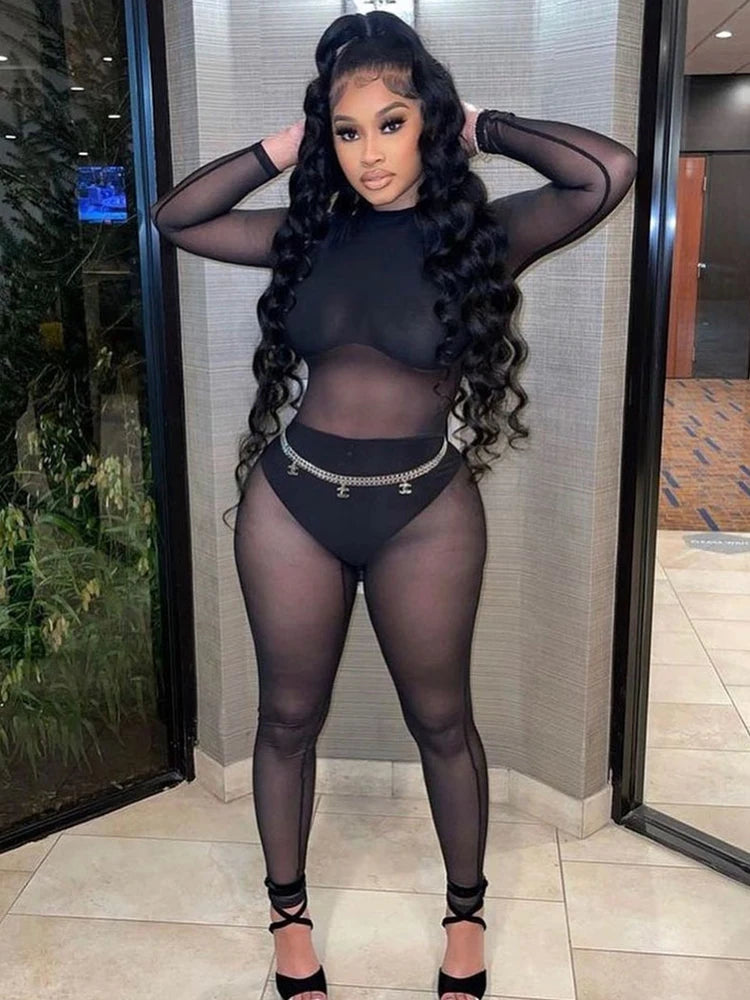Stylish woman in a Sexy Black Transparent Mesh Jumpsuit for Women Elastic See-Through Bodysuit One-Piece Nightclub Outfit.